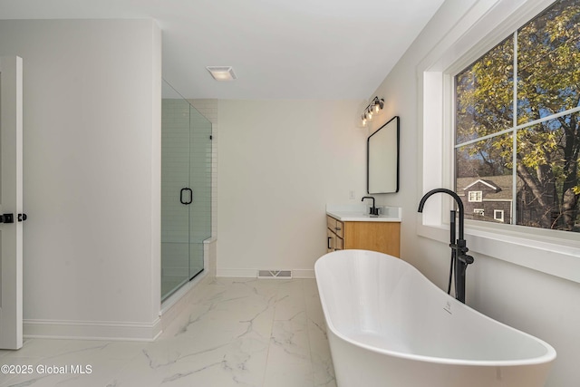 bathroom with baseboards, marble finish flooring, a stall shower, and a freestanding bath