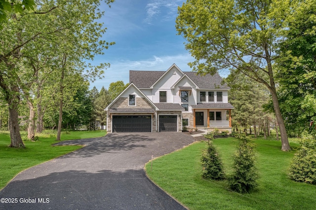 craftsman inspired home featuring board and batten siding, driveway, a front lawn, stone siding, and covered porch