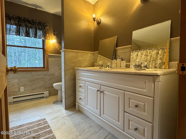 11 Beaureguard Way, Minerva, NY 12851 - full bath featuring a baseboard radiator, toilet, vanity, a wainscoted wall, and tile walls