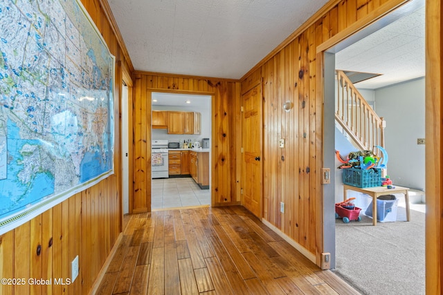 18 Main St, Berne, NY 12059 - hallway with wood walls, light wood-type flooring, stairway, baseboards, and ornamental molding