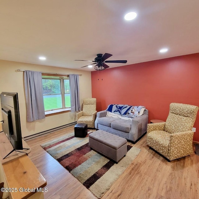 living area featuring wood finished floors, ceiling fan, recessed lighting, and a baseboard radiator