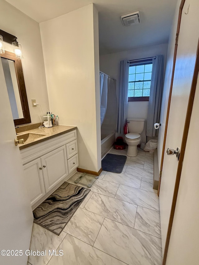 bathroom with toilet, marble look tiles, vanity, shower / bath combo with shower curtain, and baseboards