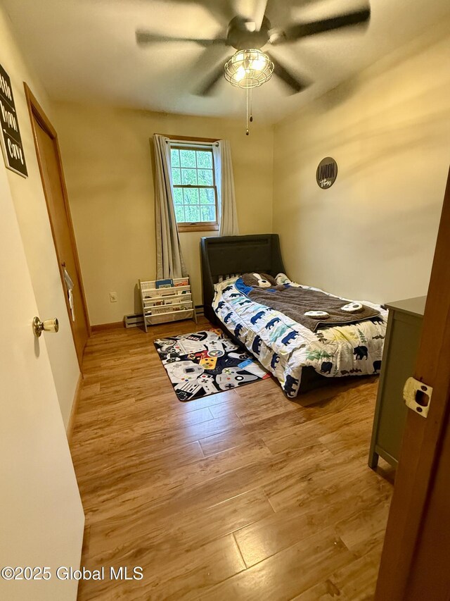 bedroom with wood finished floors, ceiling fan, and baseboards