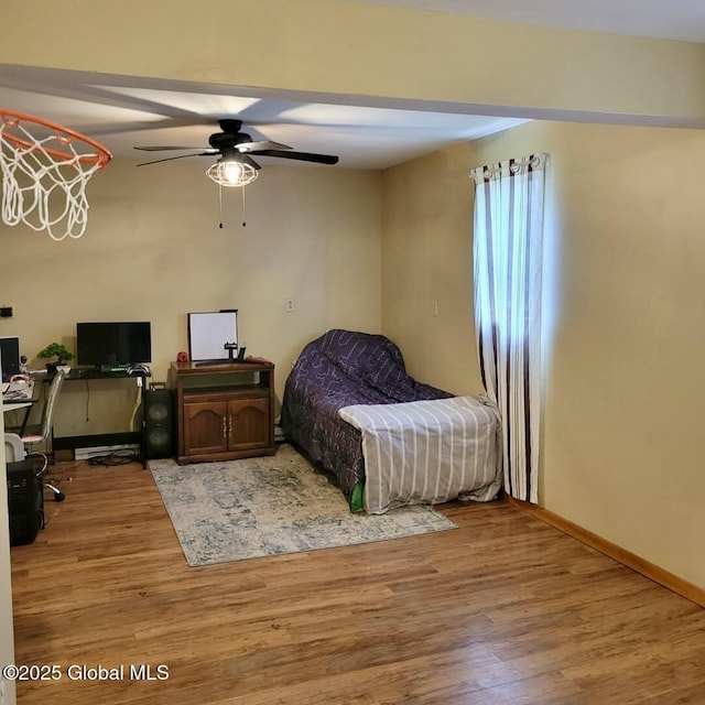 bedroom with a desk, wood finished floors, and baseboards