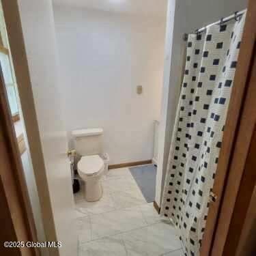 full bath with toilet and curtained shower
