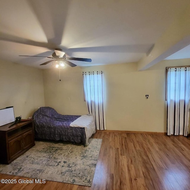 bedroom with wood finished floors, a ceiling fan, and baseboards