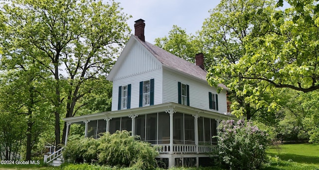 601/603 Baldwin Rd, Ticonderoga, NY 12883 - view of side of home with a sunroom, a chimney, and a lawn