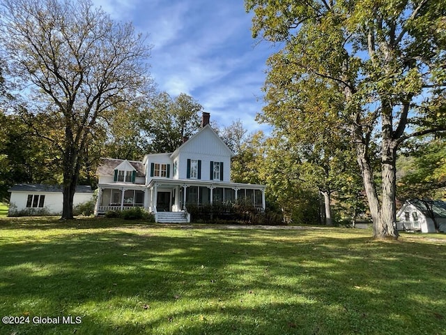 601/603 Baldwin Rd, Ticonderoga, NY 12883 - view of front facade featuring a sunroom, a front yard, and a chimney