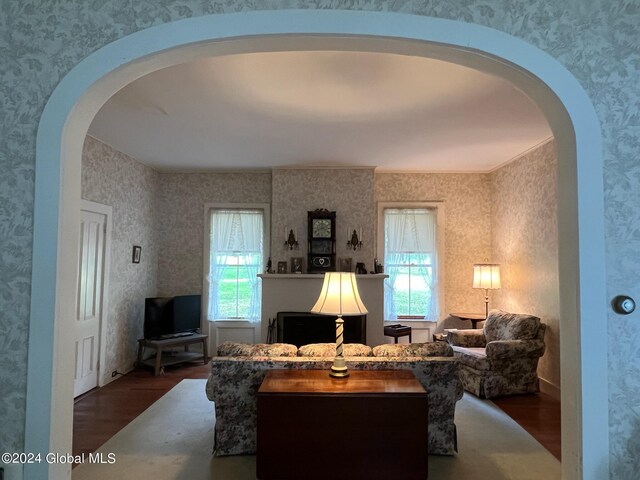 601/603 Baldwin Rd, Ticonderoga, NY 12883 - living room featuring wood finished floors, wallpapered walls, healthy amount of natural light, and arched walkways