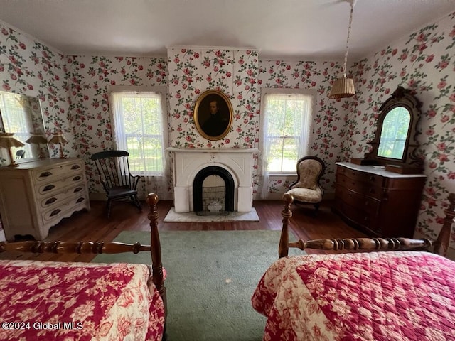601/603 Baldwin Rd, Ticonderoga, NY 12883 - bedroom with wood finished floors, wallpapered walls, multiple windows, and a fireplace with raised hearth
