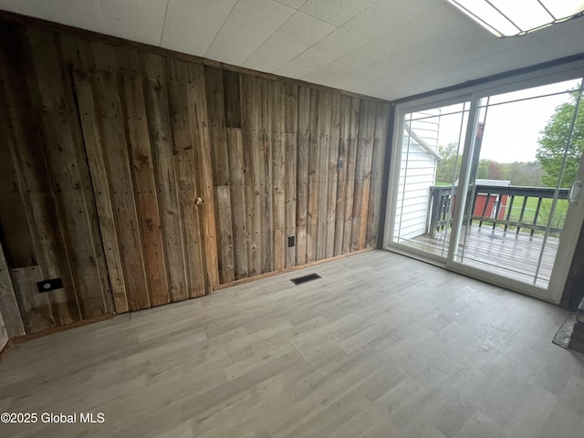 2299 Coach Rd, Argyle, NY 12809 - unfurnished room featuring wood walls, wood finished floors, and a wall of windows