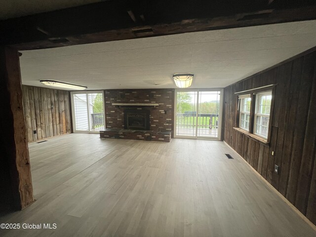 2299 Coach Rd, Argyle, NY 12809 - unfurnished living room featuring wood walls, wood finished floors, and a fireplace