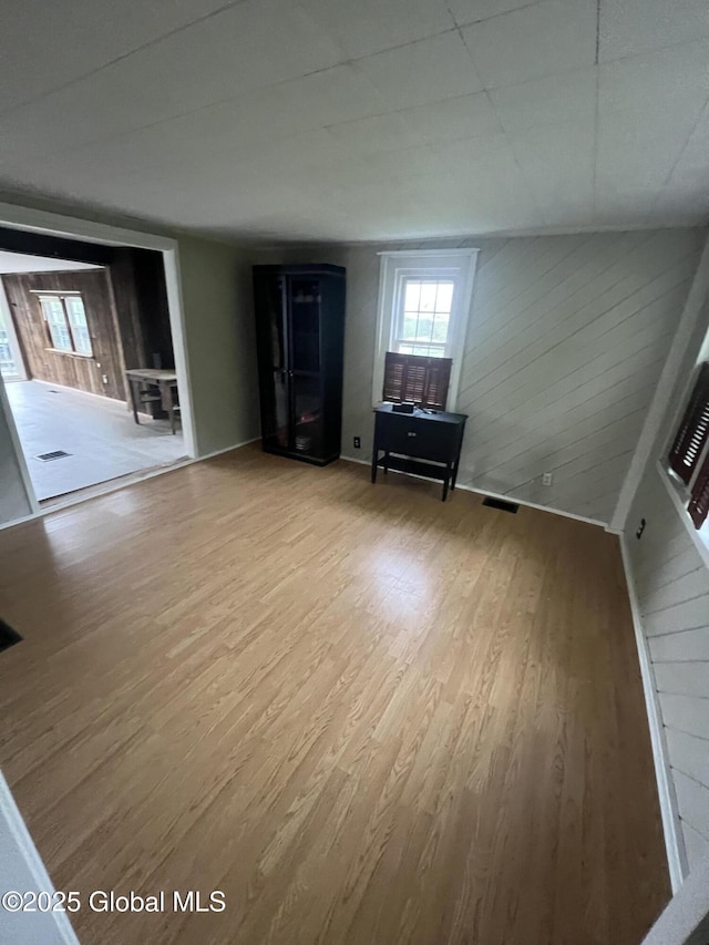 2299 Coach Rd, Argyle, NY 12809 - unfurnished living room featuring wood finished floors and wood walls