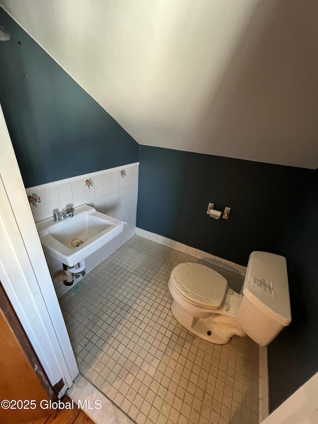 2299 Coach Rd, Argyle, NY 12809 - half bathroom featuring toilet, a sink, vaulted ceiling, and tile patterned flooring
