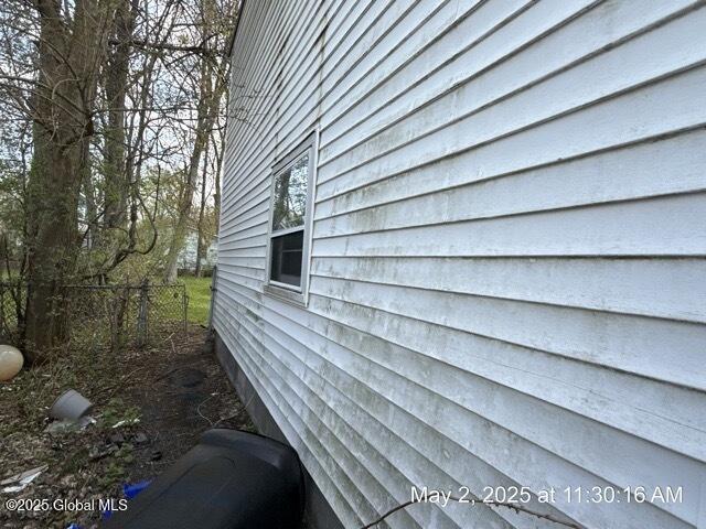 view of side of property featuring fence