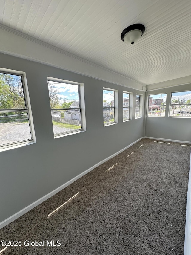 spare room featuring plenty of natural light, baseboards, and carpet floors