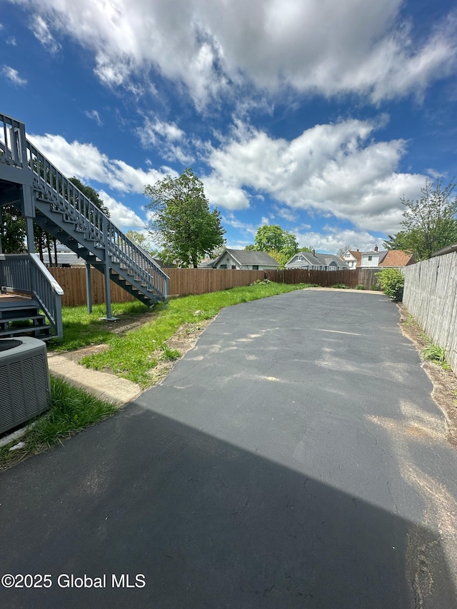 view of asphalt driveway featuring stairs