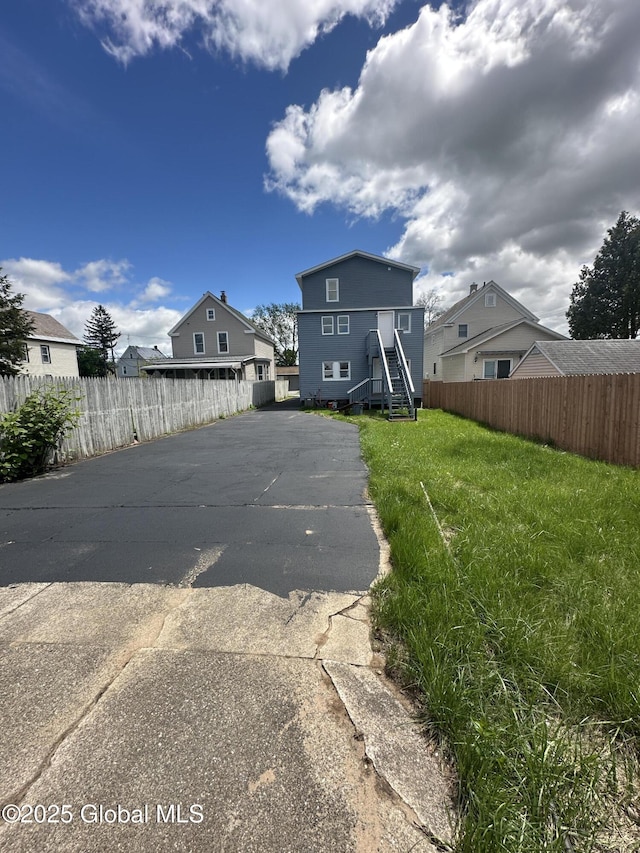 rear view of property featuring asphalt driveway