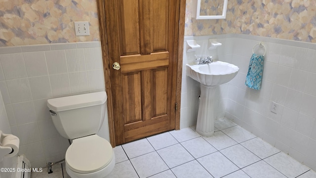 505 Elm Ave, Bethlehem, NY 12158 - bathroom featuring wallpapered walls, a wainscoted wall, tile walls, toilet, and tile patterned floors