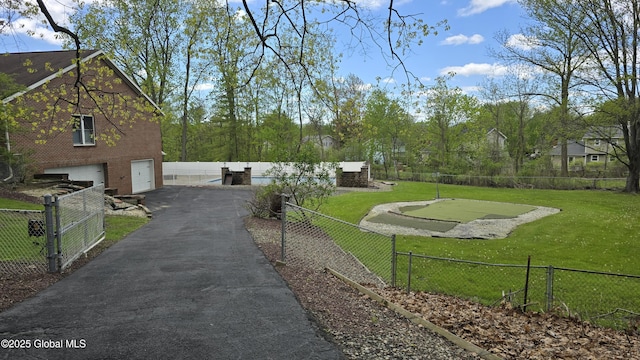 505 Elm Ave, Bethlehem, NY 12158 - view of yard with asphalt driveway, a garage, and a putting area