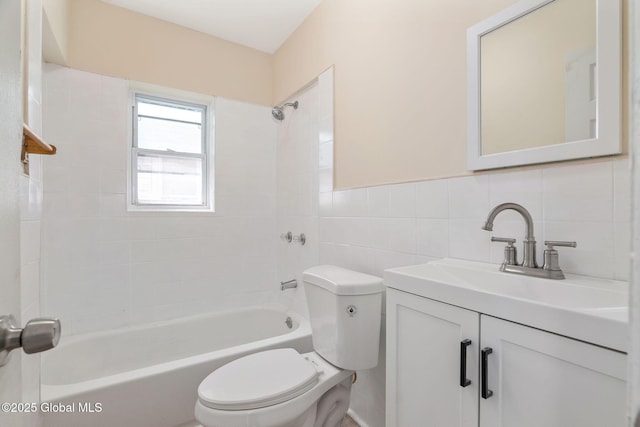 bathroom with toilet, tile walls, shower / tub combination, and vanity