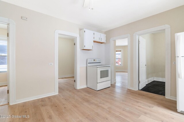 kitchen with white appliances, light wood finished floors, baseboards, and white cabinetry