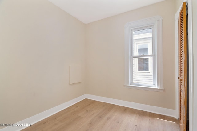 spare room with light wood-style floors and baseboards