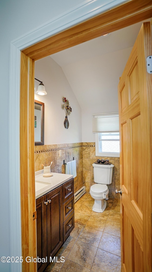 138 Church St, Saratoga Springs, Inside, NY 12866 - bathroom featuring tile walls, toilet, lofted ceiling, baseboard heating, and vanity