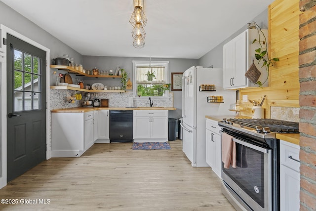 109 Wood Rd, Ballston Spa, NY 12020 - kitchen featuring stainless steel range with gas stovetop, black dishwasher, decorative backsplash, light wood-type flooring, and white cabinetry