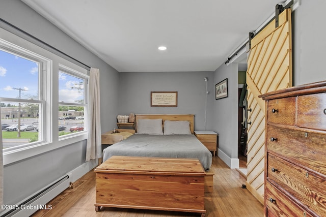 109 Wood Rd, Ballston Spa, NY 12020 - bedroom featuring a barn door, baseboard heating, light wood-style floors, multiple windows, and recessed lighting