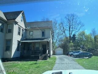 436 Lower Main St, Fort Edward, NY 12839 - view of front facade featuring a detached garage, a front yard, an outdoor structure, asphalt driveway, and covered porch