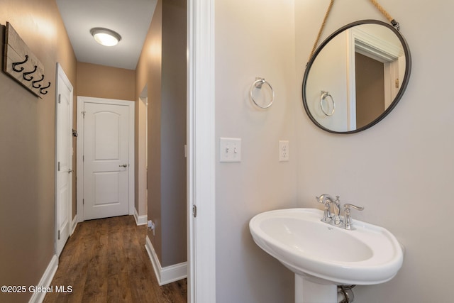 bathroom featuring a sink, wood finished floors, and baseboards