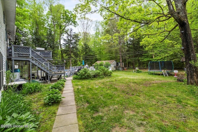 5131 Fairground Ave, Ballston Spa, NY 12020 - view of grassy yard featuring a trampoline, stairs, and a deck