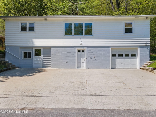 view of front of house featuring stairs, a garage, and concrete driveway