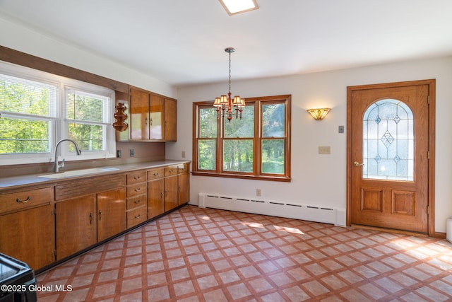 kitchen featuring a baseboard heating unit, a sink, light countertops, and brown cabinetry