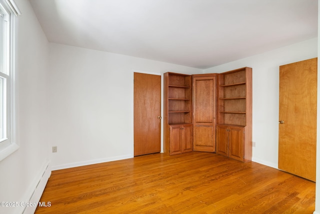 unfurnished bedroom featuring light wood finished floors and baseboards