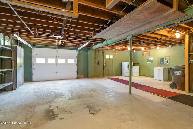 garage featuring independent washer and dryer and concrete block wall
