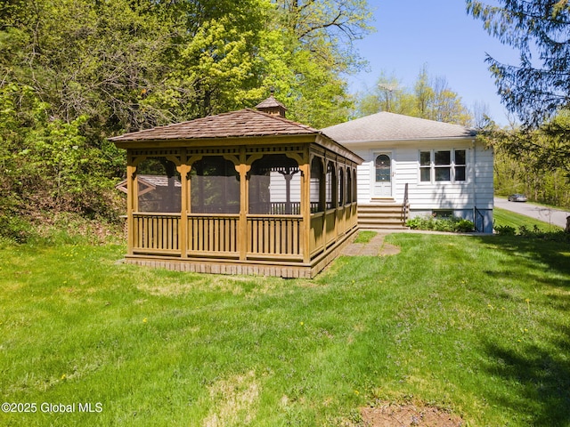 back of property featuring a gazebo, a yard, and a chimney
