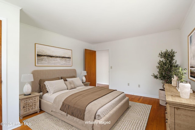bedroom featuring wood finished floors, ornamental molding, and baseboards