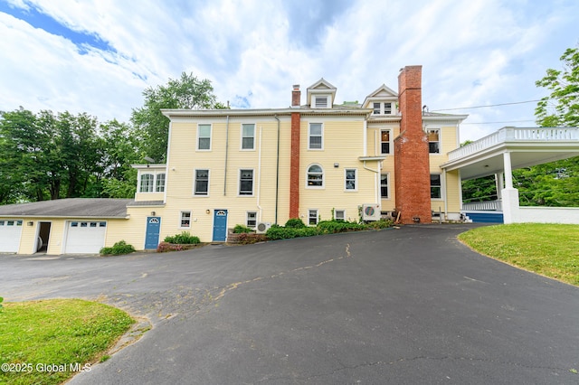 view of front of home with a chimney and asphalt driveway