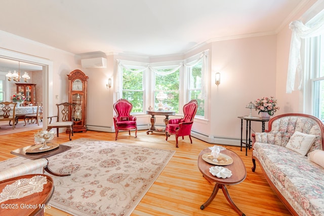 living area with baseboard heating, plenty of natural light, crown molding, light wood-style floors, and a chandelier