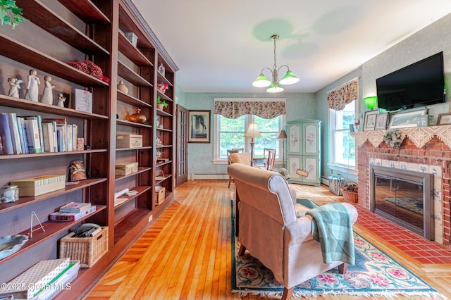 office space featuring a baseboard radiator, plenty of natural light, a fireplace, and wood finished floors