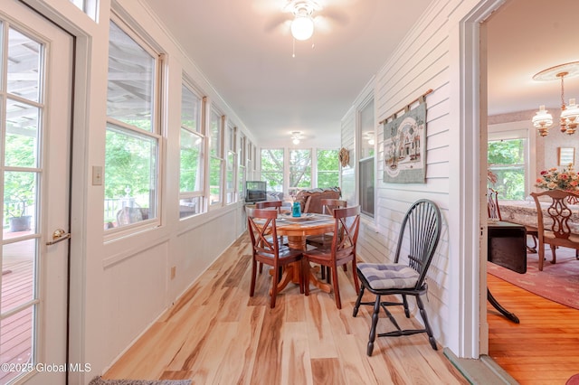 sunroom with wood finished floors and a chandelier