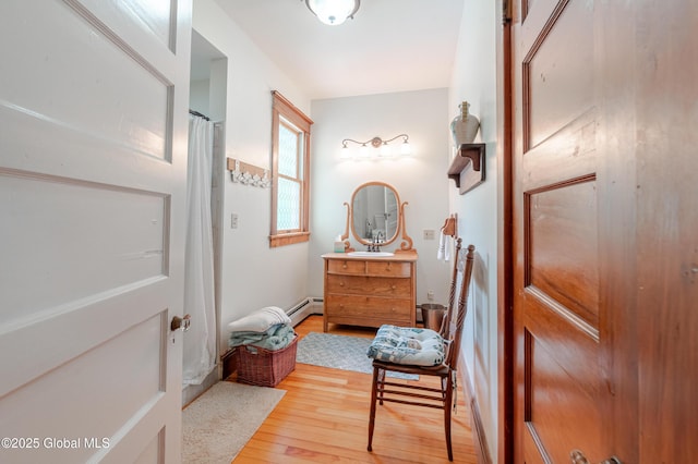 bathroom featuring a baseboard radiator, wood finished floors, and vanity