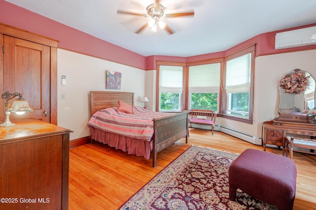 bedroom featuring light wood-style floors, a wall unit AC, a ceiling fan, baseboards, and baseboard heating