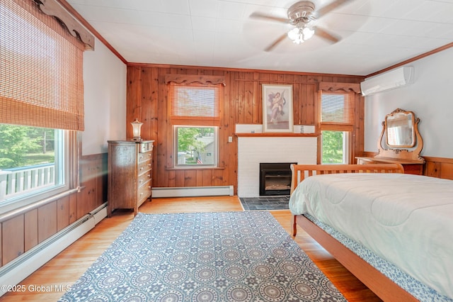 bedroom with a wall mounted AC, wooden walls, a baseboard radiator, crown molding, and a brick fireplace