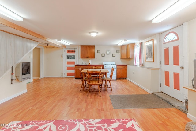 dining room featuring heating unit, light wood finished floors, and baseboards