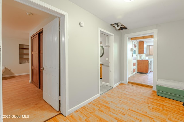 hallway with light wood-type flooring and baseboards