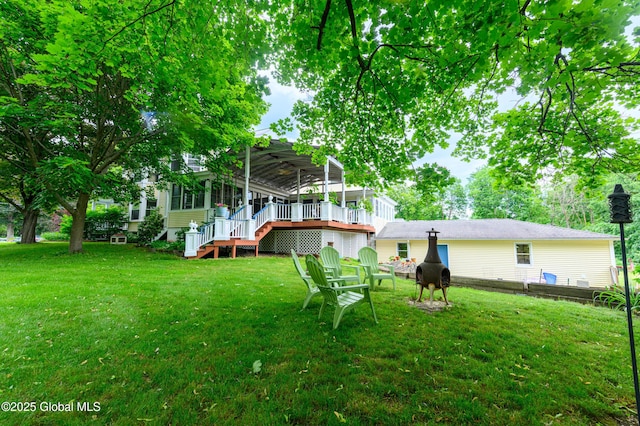 back of property with a lawn, stairway, and a deck