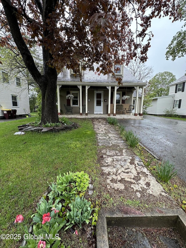 63 Elm St, Hudson Falls, NY 12839 - view of front of home with covered porch and a front lawn